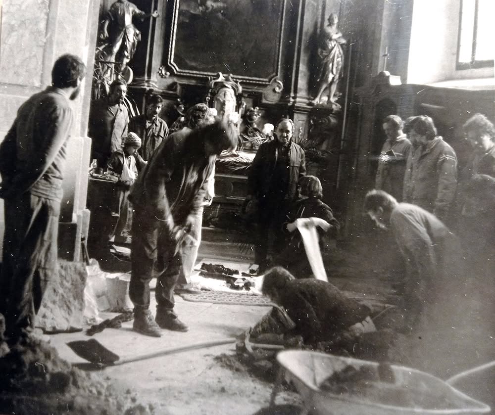 Archeologický průzkum hrobky opata Kryštofa Matušky. Před oltářem na vše dohlíží p. Tomáš Prnka. (Foto anonym). Osobní fond P037, Lubomír Šebela. Archiv Archeologického ústavu AV ČR Brno, v. v. i.